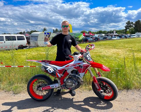Benjamin Hagmaier mit seiner roten Supermoto und einem Pokal in der Hand